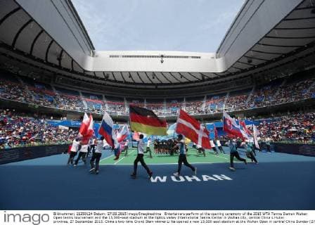 Entertainers perform at the opening ceremony of the 2015 WTA Tennis Damen Wuhan Open tennis tournament and the 15,000-seat stadium at the Optics Valley International Tennis Center in Wuhan city, central China s Hubei province, 27 September 2015. China s two-time Grand Slam winner Li Na opened a new 15,000-seat stadium at the Wuhan Open in central China Sunday (27 September 2015) to huge cheers from her hometown fans. The new stadium has been built on the back of Li s career success, she was the first Asian to win a Grand Slam singles, that saw the popularity of tennis surge in China. Huge applause echoed through the stadium as Li, now retired, stepped onto the court wearing a red dress and was joined by the tournament s defending champion Petra Kvitova to open the new stadium officially. Similar in capacity to Wimbledon s centre court, the new stadium is dwarfed only by the US Open s Arthur Ashe stadium which has a capacity of 23,000. It has a retractable roof and a metal and glass structure reminiscent of the iconic bird s nest stadium in Beijing, the centrepiece of the 2008 Olympics. Li Na thrills fans at Wuhan stadium opening 20150927_66315