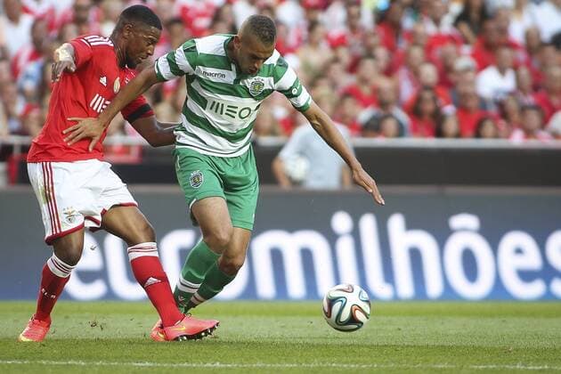 Aug. 31, 2014 - Lisbon, Portugal - Sporting«s forward Islam Slimani (R) challenges Benfica«s defender Eliseu during the Portuguese Liga football match SL Benfica vs Sporting CP at Luz stadium in Lisbon on August 31, 2014. NURPHOTO CARLOS COSTA FBL-LIGA-SPORTING-BENFICA - ZUMAn230