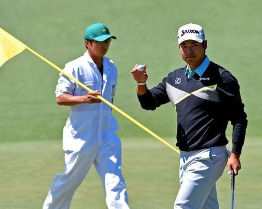 April 9, 2016 - Augusta, GA, USA - Hideki Matsuyama, right, acknowledges the applause of the gallery after making a putt on the 2nd green during the third round of the 80th Masters at the Augusta National Golf Club in Augusta, Ga., on Saturday, April 9, 2016. At left, caddie Daisuke Shindo, places the pin. Masters, third round - ZUMAm67_
