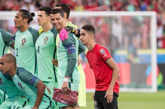 Ein Volunteer, Fan von Portugal und Cristiano RONALDO (POR, vorne) steht beim Mannschaftsfoto, Teamfoto neben seinem Idol Ronaldo, der ihn lachend ansieht; Fans, Anhaenger (Anhänger), supporter; Verehrung, Star, Heldenverehrung; Halbfinale, Portugal - Wales 2:0, in Lyon am 06.07.2016; Fussball EM 2016 in Frankreich vom 10.06. - 10.07.2016.