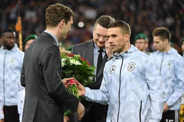 GER, FSP, Deutschland (GER) vs England (ENG) 22.03.2017, Signal-Iduna-Park , Dortmund , GER, FSP, Deutschland (GER) vs England (ENG) im Bild picture shows: ein Vertreter des DFB überreicht Lukas Podolski (Deutschland GER 10),einen Strauss Blumen Tschoe Poldi Lukas Podolski der Weltmeister bestreitet heute sein 130 Länderspiel in 13 Jahren, Emotionen, ein emotionaler Moment, Emotionen, traurig, Lukas Podolski wird für seinen Einsatz in der Nationalmannschaft über 13 Jahre geehrt und verabschiedet, Emotionen, traurig, Traenen, Ehre, Foto © nordphoto Meuter nordphotox xMeuter