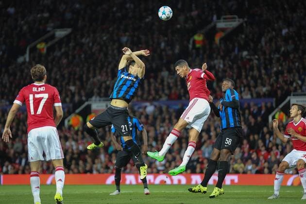 - MANCHESTER, UNITED KINGDOM: Club s Dion Cools, Manchester s Chris Smalling and Club s Obbi Oulare fight for the ball during a soccer game between British club Manchester United ManU FC and Belgian team Club Brugge KV in Manchester, United Kingdom, Tuesday 18 August 2015, the first leg of the play-offs for the UEFA Champions League competition. BRUNOxFAHY x84382013x