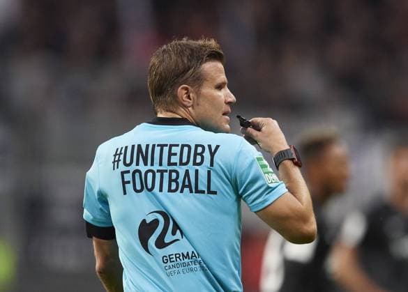 Schiedsrichter Dr. Felix BRYCH, Deutschland, Referee, Gestik, Geste, Pfeife, macht Werbung fuer die Bewerbung Europameisterschaft 2024 in Deutschland, unitedbyfootball. Fussball 1.Bundesliga, 4.Spieltag, Eintracht Frankfurt (F) - RB Leipzig (L) 1:1, am 23.09.2018 in Frankfurt Deutschland. DFL regulations prohibit any use of photographs as image sequences and or quasi-video Â