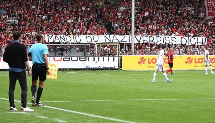 17.08.2019, xfux, Fussball 1.Bundesliga, SC Freiburg - 1. FSV Mainz 05, azspor, emspor, v.l. Fans SC Freiburg, Fan, Stimmung, Trikot, Schal, Fahne, Emotionen mit einem Banner gegen Mandic Protest ãMandic du Nazi Verpiss dich!Ò (DFL DFB REGULATIONS PROHIBIT ANY USE OF PHOTOGRAPHS as IMAGE SEQUENCES and or QUASI-VIDEO) Freiburg
