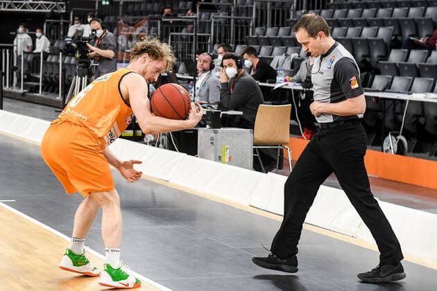 GER, BBL, ratiopharm ulm vs Basketball Löwen Loewen Braunschweig 05.04.2021, ratiopharm arena, Neu-Ulm, GER, BBL, ratiopharm ulm vs Basketball Löwen Loewen Braunschweig, im Bild Per Günther Guenther (Ulm, 6) rettet, unter Beobachtung eines Schiedsrichters, den Ball vor dem Aus