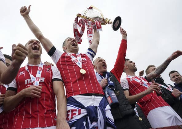 Mandatory Credit: Photo by Jed Leicester BPI Shutterstock (11893253dc) Cheltenham Town captain Ben Tozer lifts the EFL Sky Bet League Two trophy as the team celebrates in the car park in front of the fans outside the ground Cheltenham Town v Harrogate Town, EFL Sky Bet League Two, Football, The Jonny-Rocks Stadium, Cheltenham, UK - 08 May 2021 EDITORIAL USE ONLY No use with unauthorised audio, video, data, fixture lists, club league logos or live services. Online in-match use limited to 120 images, no video emulation. No use in betting, games or single club league player publications. Cheltenham Town v Harrogate Town, EFL Sky Bet League Two, Football, The Jonny-Rocks Stadium, Cheltenham, UK - 08 May 2021 EDITORIAL USE ONLY No use with unauthorised audio, video, data, fixture lists, club league logos or live services. Online in-match use limited to 120 images, no video emulation. No use in betting, games or single club league player publications. Copyright: xJedxLeicester BPI Shutterstockx 11893253dc
