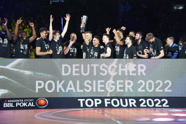 DEU, TOP4, Pokal, ALBA vs. Crailsheim, 20.02.2022, Mercedes-Benz-Arena, Berlin, DEU, TOP4, Pokal, ALBA vs. Crailsheim, im Bild Maodo Lo (ALBA Berlin 0) mit dem Pokal, Luke Sikma (ALBA Berlin 43), ALBA-Spielerkreis