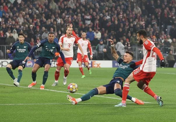 Noussair Mazraoui of Bayern Munich has a shot despite the attentions of Ben White of Arsenal Bayern Munich v Arsenal, UEFA Champions League, Quarter Final, Second Leg, Football, Allianz Arena, Munich, Germany - 17 Apr 2024 EDITORIAL USE ONLY No use with unauthorised audio, video, data, fixture lists, club league logos or live services. Online in-match use limited to 120 images, no video emulation. No use in betting, games or single club league player publications. Copyright: xMichaelxZemanek Shutterstockx 14434936v