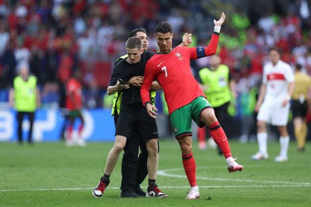 A fan enters the pitch during the match and grabs Cristiano Ronaldo of Portugal Turkiye v Portugal, UEFA European Championship, EM, Europameisterschaft 2024, Group F, Football, BVB Stadion, Dortmund, Germany, 22 Jun 2024 EDITORIAL USE ONLY No use with unauthorised audio, video, data, fixture lists, club league logos or live services. Online in-match use limited to 120 images, no video emulation. No use in betting, games or single club league player publications. Copyright: xPaulxCurrie Shutterstockx 14548034et