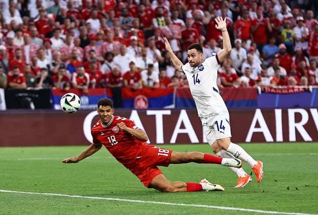 Alexander Bah of Denmark has an attempt on goal whilst under pressure from Andrija Zivkovic of Serbia Denmark v Serbia, UEFA European Championship, EM, Europameisterschaft 2024, Group C, Football, Munich Football Arena, Munich, Germany, 25 Jun 2024 EDITORIAL USE ONLY No use with unauthorised audio, video, data, fixture lists, club league logos or live services. Online in-match use limited to 120 images, no video emulation. No use in betting, games or single club league player publications. Copyright: xMichaelxZemanek Shutterstockx 14555536av