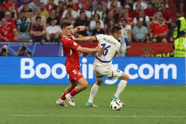 im Zweikampf, Aktion, mit Joakim Maehle 5 (Daenemark), Srdjan Mijailovic 16 (Serbien), Daenemark vs. Serbien, Fussball, UEFA EURO, EM, Europameisterschaft,Fussball 2024, Gruppenphase, 3. Spieltag, 25.06.2024 Muenchen Bayern Deutschland
