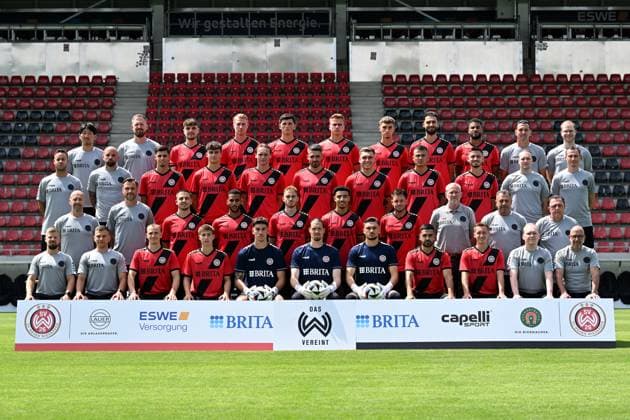 18.07.2024, xjhx, Fussball 3.Liga, SV Wehen Wiesbaden - Fototermin Saison 2024 25, Porträttermin 2024 2025, Mannschaftsfoto emspor, Hintere Reihe von links: Physiotherapeut Shohei Nozawa, Athletik-Trainer Sebastian Wagener, Gino Fechner, Bjarke Jacobsen, Moritz Flotho, Florian Carstens, Justin Janitzek, Nikolas Agrafiotis, Martin Angha, Torwart-Trainer Marjan Petkovic, Scout Konstantin Langhammer 2. Reihe von links: Leiter Prävention & Rehabilitation Javier Cordero, Co-Trainer Analyse Giuliano Modica, Ivan Franjic, Ben Nink, Ryan Johansson, Sascha Mockenhaupt, Marius Wegmann, Antonio Jonjic, Nico Rieble, Team-Manager Patrick Glaser, Spiel-Analyst Phil Weimer 3. Reihe von links: Co-Trainer Frank Steinmetz, Chef-Trainer Nils Döring, Amar Catic, Amin Farouk, Ole Wohlers, Nassim El Ouarti, Thijmen Goppel, Geschäftsführer Uwe Stöver, Betreuer Gerhard Eckel, Betreuer Thorsten Conradi Vordere Reihe von links: Leiter Physiotherapie Robin Reitze, Athletik-Trainer Dominik Hönig, Emanuel Taffertshofer, Nick Bätzner, Noah Brdar, Florian Stritzel, Arthur Lyska, Tarik Gözüsirin, Fabian Greilinger, Leiter Scouting Philipp Gründler, Mannschaftsarzt Dr. Achim Bitschnau Es fehlt: Mohamed Amsif (DFL DFB REGULATIONS PROHIBIT ANY USE OF PHOTOGRAPHS as IMAGE SEQUENCES and or QUASI-VIDEO) Wiesbaden