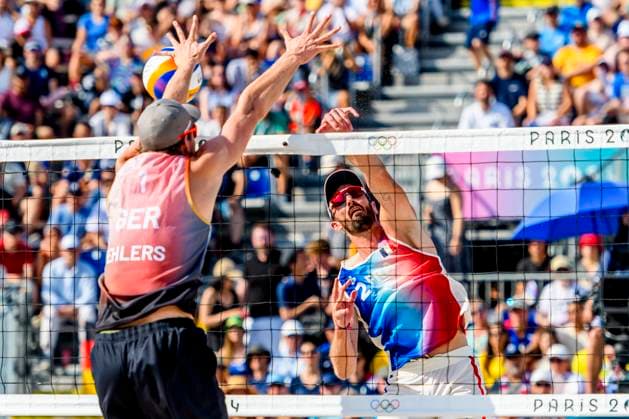 FRA, Olympische Sommerspiele Paris 2024, Beach volleyball, Beachvolleyball , Vorrunde - Gruppe C, Spiel 3, Ehlers Wickler (GER) vs Bassereau Lyneel (FRA) 30.07.2024, Champ de Mars, Paris, FRA, Olympische Sommerspiele Paris 2024, Beach Volleyball , Vorrunde - Gruppe C, Spiel 3, Ehlers Wickler (GER) vs Bassereau Lyneel (FRA) , im Bild Ehlers Nils (GER) vs Lyneel Julien(FRA)