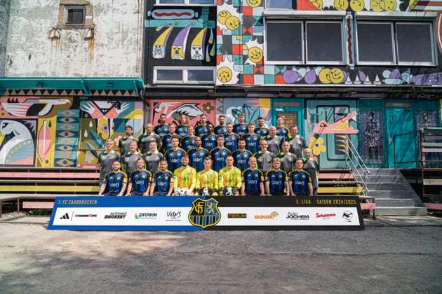 3.Liga - 1.FC Saarbruecken - Fotoshooting - Fototermin - Fussball - Saison 2024 25 - SB - Mannschaftsfoto des Drittligisten 1.FC Saarbrücken am 18.07.2024 , in Saarbrücken vor dem Silo Osthafen . Im Bild Obere Reihe v.l. Simon Stehle , Tim Civeja , Amine Naifi , Kasim Rabihic , Dominik Becker , Maurice Multhaup , Till Schumacher . 3. Reihe v.l. : Athletiktrainer Max Smith , Torwarttrainer Michael Weirich , Julian Günther-Schmidt , Manuel Zeitz , Elijah Krahn , Patrick Schmidt , Lasse Wilhelm , Betreuer Rüdiger Schmidti , Busfahrer Torsten Bard . 2. Reihe: Trainer Rüdiger Ziehl , Co-Trainer Bernd Heemsoth , Co-Trainer Yannic Thiel , Bjarne Thoelke , Bone Uaferro , Sven Sonnenberg , Kai Brünker , Paulo DaPalma , Frank Sänger , Helmut Schwan . 1.Reihe (unten, v.l.): Calogero Rizzuto , Richard Neudecker , Chafik Gourichy , Phillip Menzel , David Mutter , Tim Paterok , Sebastian Vasiliadis , PhilipFahrner , Patrick Sontheimer . Saarbrücken Silo - Am Osthafen Saarland Deutschland