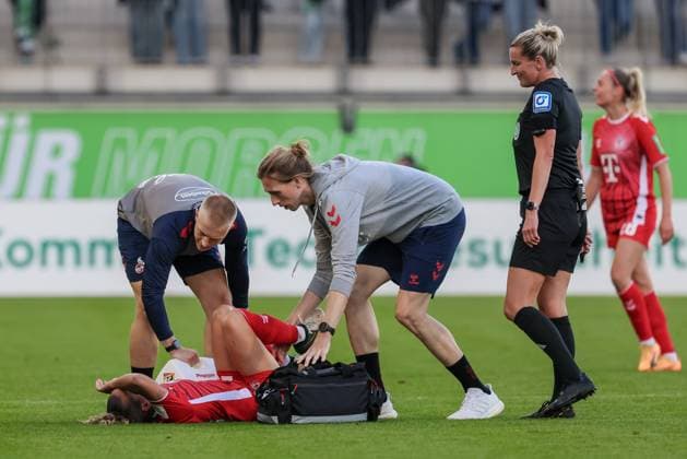v.li.: Vanessa Leimenstoll (1. FC Köln, 29) wird verletzt behandelt, Verletzung, Schmerzen, schmerzverzerrtes Gesicht, liegt verletzt am Boden, Verletzung, Schmerzen, schmerzverzerrtes Gesicht, DIE DFB-RICHTLINIEN UNTERSAGEN JEGLICHE NUTZUNG VON FOTOS ALS SEQUENZBILDER UND ODER VIDEOÄHNLICHE FOTOSTRECKEN. DFB REGULATIONS PROHIBIT ANY USE OF PHOTOGRAPHS AS IMAGE SEQUENCES AND OR QUASI-VIDEO., 22.09.2024, Wolfsburg (Deutschland), Fussball, Google Pixel Frauen-Bundesliga, VfL Wolfsburg - 1. FC Köln