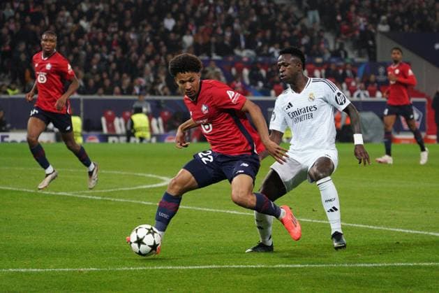 Tiago Santos of Lille shields the ball from Vinicius Junior of Real Madrid Lille v Real Madrid, UEFA Champions League, Group Stage, Football, Pierre Mauroy Stadium, Lille, France, 02 Oct 2024 EDITORIAL USE ONLY No use with unauthorised audio, video, data, fixture lists, club league logos or live services. Online in-match use limited to 120 images, no video emulation. No use in betting, games or single club league player publications. Copyright: xDavexWinter Shutterstockx 14750773id