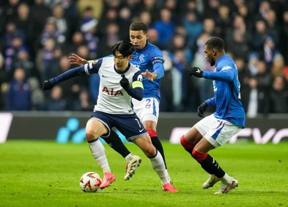 Tottenham Hotspur captain Son Heung-Min challenges for the ball with Rangers captain James Tavernier & Dujon Sterling of Rangers. Rangers v Tottenham Hotspur, UEFA Europa League, Group Stage, Football, Ibrox Stadium, Glasgow, Scotland - 12 Dec 2024 EDITORIAL USE ONLY No use with unauthorised audio, video, data, fixture lists, club league logos or live services. Online in-match use limited to 120 images, no video emulation. No use in betting, games or single club league player publications. Copyright: xStuartxWallace Shutterstockx 14985154dr