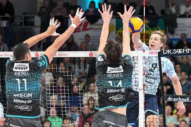 v.li.: Michael Andrei (Powervolleys Düren, 11), Matthew Neaves (Powervolleys Düren, 14) bilden den Block, Matthew Slivinski (ASV Dachau, 9) schmettert einen Ball, Aktion, Action, Spielszene, 29.12.2024, Düren (Deutschland), Volleyball, 1. Bundesliga Männer, SWD Powervolleys Düren - ASV Dachau