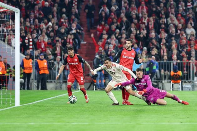 im Zweikampf, Aktion, mit Piero Hincapie 3 (Bayer 04 Leverkusen), Mario Hermoso 5 (Bayer 04 Leverkusen), Jamal Musiala 42 (FC Bayern Muenchen), Matej Kovar 17 (Bayer 04 Leverkusen), trifft das Tor zum 2:0, FC Bayern Muenchen vs. Bayer 04 Leverkusen, Fussball, Champions League, Achtelfinale, Hinspiel, 05.03.2025 Muenchen Bayern Deutschland
