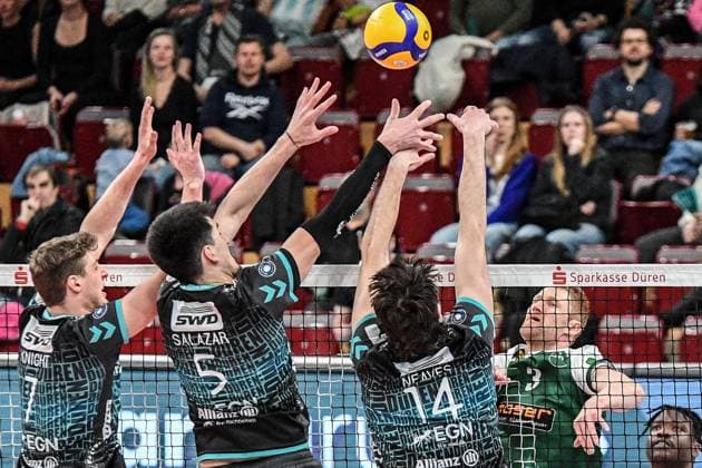 v.li.: Alex Knight (Powervolleys Düren, 7), Imanol Salazar (Powervolleys Düren, 5), Matthew Neaves (Powervolleys Düren, 14) bei der Blockbildung, Yannik Harms (FT 1844 Freiburg, 3) legt den Ball über das Netz, Aktion, Action, Spielszene, 14.03.2025, Düren (Deutschland), Volleyball, 1. Bundesliga Männer, SWD Powervolleys Düren - FT 1844 Freiburg