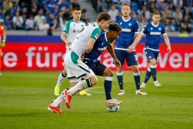 Phil Neumann (Hannover 96, 05) und Bambase Conte (Karlsruher SC, 31) im Laufduell , Deutschland, Fussball, 2. Bundesliga, .Spieltag, 2024 2025, Karlsruher SC vs. Hannover 96, 04.04.2025, BBBank Wildpark, Karlsruhe, Deutschland DFL REGULATIONS PROHIBIT ANY USE OF PHOTOGRAPHS AS IMAGE SEQUENCES AND OR QUASI-VIDEO. Karlsruhe BBBank Wildpark Baden-Württemberg Deutschland