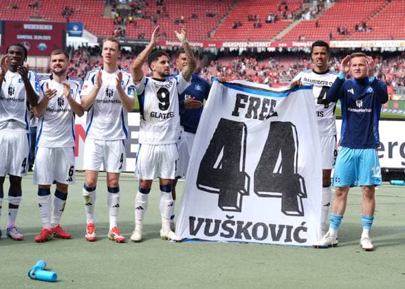 Hamburger SV Spieler halten ein Schild mit der Aufschrift Free Vuskovic in der Hand, das sich auf den kroatischen Nationalspieler bezieht, der derzeit eine vierjaehrige Sperre fuer die Liga verbuesst. GER, 1.FC Nuernberg vs Hamburger SV, 2. Bundesliga, 28. Spieltag, Saison 2024 2025, 05.04.2025 DFL REGULATIONS PROHIBIT ANY USE OF PHOTOGRAPHS AS IMAGE SEQUENCES AND OR QUASI-VIDEO GER, 1.FC Nuernberg vs Hamburger SV, 2. Bundesliga, 28. Spieltag, Saison 2024 2025, 05.04.2025 Nuernberg