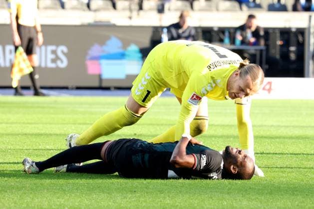 DEU, DFL, 2. FBL, Hertha BSC vs. 1.FC Magdeburg, 25.04.2025, Berliner Olympiastadion, Berlin, DEU, DFL, 2. FBL, Hertha BSC vs. 1.FC Magdeburg, im Bild Dominik Reimann (1.FC Magdeburg 1), Silas Gnaka (1.FC Magdeburg 25) verletzt DFL - regulations prohibit any use of Photographs as image sequences and or quasi-video