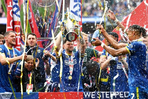 AFC Wimbledon players with the Sky Bet League Two Play-Off Final trophy in front of winners boards AFC Wimbledon v Walsall, EFL Sky Bet League Two, Play-Off Final, Football, Wembley Stadium, London, UK - 26 May 2025 EDITORIAL USE ONLY No use with unauthorised audio, video, data, fixture lists, club league logos or live services. Online in-match use limited to 120 images, no video emulation. No use in betting, games or single club league player publications. Copyright: xSimonxDael Shutterstockx 15316455gc