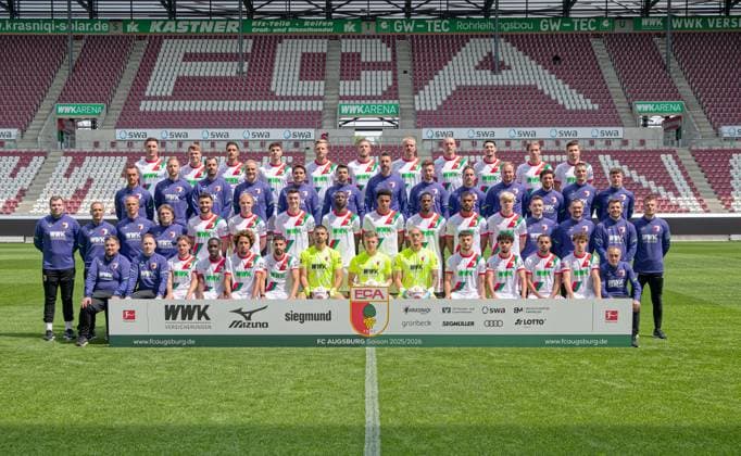 FC Augsburg 1907; 1. BL, Porträttermin 2025 2026, Mannschaftsfoto,hintere Reihe v. l.: Keven Schlotterberck, Robin Fellhauer, Dimitrios Giannoulis, Mert Kömür, Arne Maier, Jeffrey Gouweleeuw, Phillip Tietz, Marius Wolf, Yusuf Kabadayi, Kristijan Jakic, Elvis Rexhbecaj.Dritte Reihe v.l.: Reha- und Athletik-Trainer Andreas Bäumler, Leiter Athletik-Training, Co-Trainer Individual David Binder, Torwarttrainer Marco Langner, Co-Trainer Imre Szabics, Co-Trainer Thomas Kasparetti, Cheftrainer Sandro Wagner, Co-Trainer Sven Palinkasch, Co-Trainer Analyse Julian Lauer, Spiel- und Videoanalyst Felix Kling, Spiel- und Videoanalyst Benedikt Brust, Reha- und Athletik-Trainer Frank Roßner, Leiter Physiotherapie Nikolaus Guschl.Zweite Reihe v. l.: Teamkoordinator Jan Reckord, Mannschaftsarzt Dr. Karsten Bogner, Mannschaftsarzt Dr. Jens Otto, Mannschaftsarzt Dr. Andreas Weigel, Maximilian Bauer, Tim Breithaupt, Cedric Zesiger, Chrislain Matsima, Noahkai Banks, Samuel Essende, Steve Mounie, Felix Meiser, Reha- und Athletik-Trainer Christian Hahn, Physiotherapeut David Müller, Physiotherapeut Marcel Schoder, Physiotherapeut Julian Binder.Untere Reihe v. l.: Zeugwart Christoph Schade, Teamanger Philipp Dolla, Mads Pedersen, Kyliane Dong, Han-Noah Massengo, Elias Saad, Nediljko Labrovic, Finn Dahmen, Daniel Klein, Mahmut Kücüksahin, Aiman Dardari, Alexis Claude-Maurice, Oliver Sorg, Zeugwart Salvatore Belardo.
