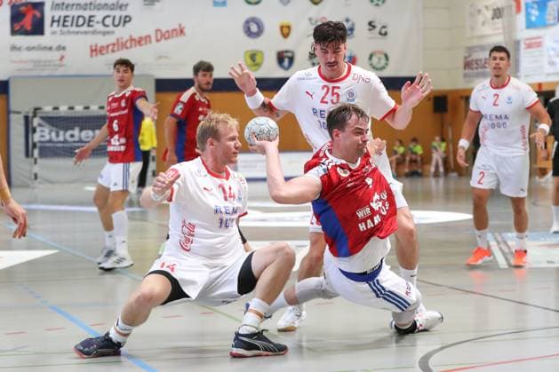 08.08.2025, xgox, Handball - Heide-Cup, Handball Verein Hamburg - Kolstad Handbold emspor, v.l. Magnus Gullerud (Kolstad, 14), Andreas Magaard (Hamburg, 4), Simen Ulstad Lyse (Kolstad, 25) Zweikampf, Duell, Kampf, tackle Schneverdingen