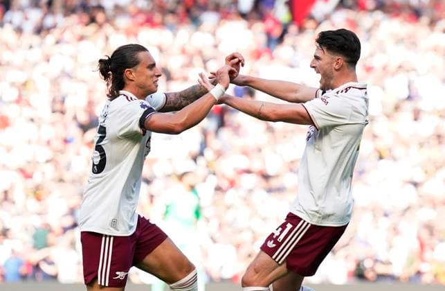 Manchester, England, 17th August 2025. Riccardo Calafiori of Arsenal (l) celebrates scoring with provider Declan Rice of Arsenal (r) during the Manchester United, ManU vs Arsenal Premier League match at Old Trafford, Manchester. Picture credit should read: Andrew Yates Sportimage EDITORIAL USE ONLY. No use with unauthorised audio, video, data, fixture lists, club league logos or live services. Online in-match use limited to 120 images, no video emulation. No use in betting, games or single club league player publications. SPI_024_AY_ManUtd_Arsenal SPI-4072-0039