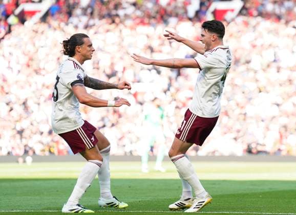 Manchester, England, 17th August 2025. Riccardo Calafiori of Arsenal (l) celebrates scoring with provider Declan Rice of Arsenal (r) during the Manchester United, ManU vs Arsenal Premier League match at Old Trafford, Manchester. Picture credit should read: Andrew Yates Sportimage EDITORIAL USE ONLY. No use with unauthorised audio, video, data, fixture lists, club league logos or live services. Online in-match use limited to 120 images, no video emulation. No use in betting, games or single club league player publications. SPI_026_AY_ManUtd_Arsenal SPI-4072-0041
