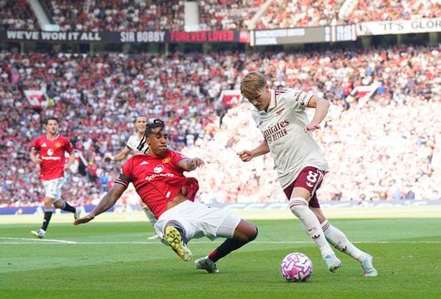 Manchester, England, 17th August 2025. Leny Yoro of Manchester United, ManU attempts to block Martin Odegaard of Arsenal during the Manchester United vs Arsenal Premier League match at Old Trafford, Manchester. Picture credit should read: Andrew Yates Sportimage EDITORIAL USE ONLY. No use with unauthorised audio, video, data, fixture lists, club league logos or live services. Online in-match use limited to 120 images, no video emulation. No use in betting, games or single club league player publications. SPI_028_AY_ManUtd_Arsenal SPI-4072-0044