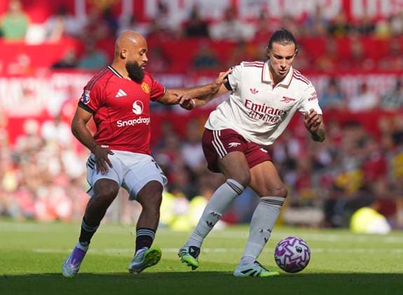 Manchester, England, 17th August 2025. Bryan Mbeumo of Manchester United, ManU tussles with Riccardo Calafiori of Arsenal during the Manchester United vs Arsenal Premier League match at Old Trafford, Manchester. Picture credit should read: Andrew Yates Sportimage EDITORIAL USE ONLY. No use with unauthorised audio, video, data, fixture lists, club league logos or live services. Online in-match use limited to 120 images, no video emulation. No use in betting, games or single club league player publications. SPI_031_AY_ManUtd_Arsenal SPI-4072-0046