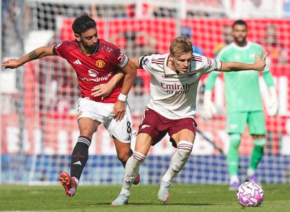 Manchester, England, 17th August 2025. Bruno Fernandes of Manchester United, ManU and Martin Odegaard of Arsenal during the Manchester United vs Arsenal Premier League match at Old Trafford, Manchester. Picture credit should read: Andrew Yates Sportimage EDITORIAL USE ONLY. No use with unauthorised audio, video, data, fixture lists, club league logos or live services. Online in-match use limited to 120 images, no video emulation. No use in betting, games or single club league player publications. SPI_032_AY_ManUtd_Arsenal SPI-4072-0047