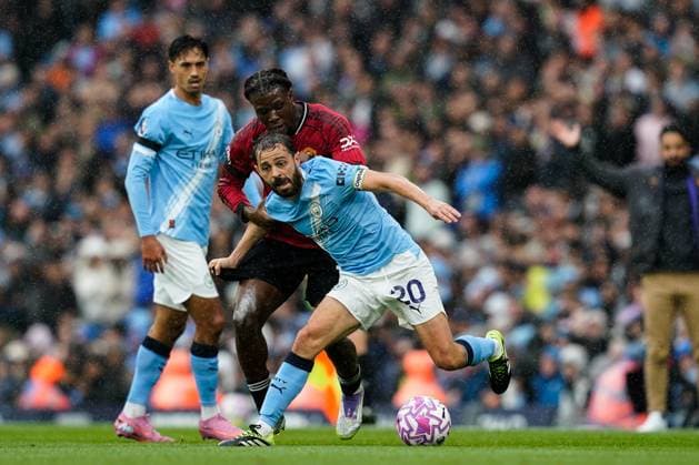 Manchester, England, 14th September 2025. Bernardo Silva of Manchester City holds off Patrick Dorgu of Manchester United, ManU during the Manchester City vs Manchester United Premier League match at the Etihad Stadium, Manchester. Picture credit should read: Andrew Yates Sportimage EDITORIAL USE ONLY. No use with unauthorised audio, video, data, fixture lists, club league logos or live services. Online in-match use limited to 120 images, no video emulation. No use in betting, games or single club league player publications. SPI_029_AY_MCI_MUFC SPI-4139-0029