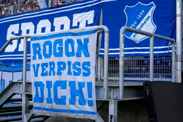 Die Ultras der TSG 1899 Hoffenheim haben einen Banner vor die Fankurve gehängt mit der Aufschrift: Rogon verpiss dich, Fans, Publikum, Zuschauer, Stimmung, Atmosphäre, Stadion, Protest, Protestaktion gegen den Berater Roger Wittmann (Agentur ROGON Sportmanagement), protestieren, Aktion, Action, 20.09.2025, Sinsheim (Deutschland), Fussball, Bundesliga, TSG 1899 Hoffenheim - FC Bayern München, DFB DFL REGULATIONS PROHIBIT ANY USE OF PHOTOGRAPHS AS IMAGE SEQUENCES AND OR QUASI-VIDEO.