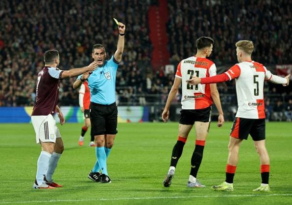 Referee Rade Obrenovic shows a yellow card to Anel Ahmedhodzic of Feyenoord as John McGinn of Aston Villa reacts Feyenoord v Aston Villa, UEFA Europa League, Group Stage, Football, De Kuip, Rotterdam, Netherlands - 02 Oct 2025Rotterdam De Kuip Netherlands EDITORIAL USE ONLY No use with unauthorised audio, video, data, fixture lists, club league logos or live services. Online in-match use limited to 120 images, no video emulation. No use in betting, games or single club league player publications. Copyright: xBartxStoutjesdijk Shutterstockx 15504059ae