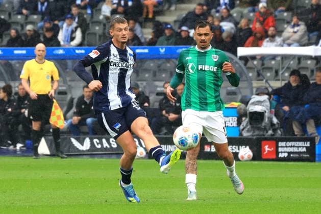 DEU, DFL, 2. FBL, Hertha BSC vs. Preussen Muenster, 04.10.2025, Berliner Olympiastadion, Berlin, DEU, DFL, 2. FBL, Hertha BSC vs. Preussen Muenster, im Bild Michael Cuisance (Hertha BSC Berlin 10), Oliver Batista Meier(Preussen Muenster 17) DFL - regulations prohibit any use of Photographs as image sequences and or quasi-video
