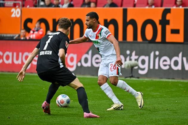 GER, Bayern, Augsburg, Fussball, FC Augsburg - VfL Wolfsburg, in der WWK Arena, Augsburg, 6. Spieltag, 04.10.25, v.l. Andreas Skov Olsen (VfL Wolfsburg, 7), Elias Saad (FC Augsburg, 26), im Zweikampf, Angriff DFL DFB regulations prohibit any use of photographs as image sequences and or quasi-video, Copyright: HMB-Media MichaelxNibel