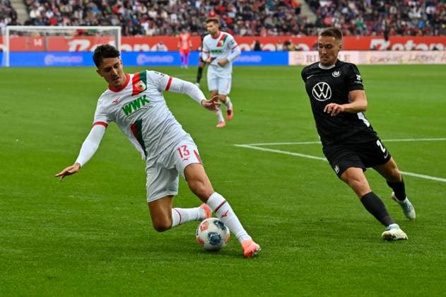 GER, Bayern, Augsburg, Fussball, FC Augsburg - VfL Wolfsburg, in der WWK Arena, Augsburg, 6. Spieltag, 04.10.25, v.l. Dimitrios Giannoulis (FC Augsburg, 13), Kilian Fischer (VfL Wolfsburg, 2), im Zweikampf, Angriff DFL DFB regulations prohibit any use of photographs as image sequences and or quasi-video, Copyright: HMB-Media MichaelxNibel