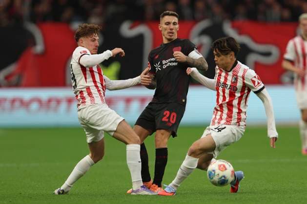 Philipp Treu (SC Freiburg), Alejandro Grimaldo (Bayer 04 Leverkusen) und Yuito Suzuki (SC Freiburg) im Zweikampf waehrend des spiels der Bundesliga zwischen Bayer 04 Leverkusen und Club Freiburg, BayArena am 26. October 2025 in Leverkusen, Deutschland. (Foto von Oliver Kaelke DeFodi Images) +++ Philipp Treu (SC Freiburg), Alejandro Grimaldo (Bayer 04 Leverkusen) und Yuito Suzuki (SC Freiburg) battle for the ball during the Bundesliga match between Bayer 04 Leverkusen and Sport-Club Freiburg at BayArena on October 26, 2025 in Leverkusen, Germany. (Photo by Oliver Kaelke DeFodi Images) DFL regulations prohibit any use of photographs as image sequences and or quasi-video. (Photo by Oliver Kaelke DeFodi Images) Philipp Treu SC Freiburg , Alejandro Grimaldo Bayer 04 Leverkusen and Yuito Suzuki SC Freiburg battle for the ball during the Bundesliga match between Bayer 04 Leverkusen and Sport Club Freiburg at BayArena on October 26, 2025 in Leverkusen, Germany Photo by Oliver Kaelke DeFodi Images Philipp Treu SC Freiburg , Alejandro Grimaldo Bayer 04 Leverkusen and Yuito Suzuki SC Freiburg battle for the ball during the Bundesliga match between Bayer 04 Leverkusen and Sport Club Freiburg at BayArena on October 26, 2025 in Leverkusen, Germany Photo by Oliver Kaelke DeFodi Images DFL regulations prohibit any use of photographs as image sequences and or quasi video Photo by Oliver Kaelke DeFodi Images