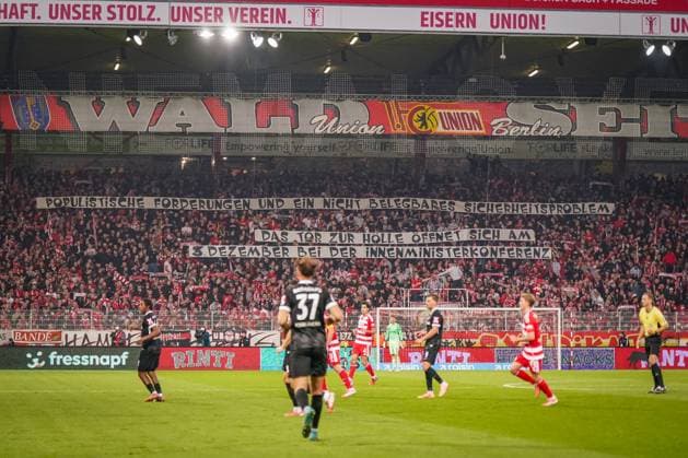 Deutschland: Fussball Bundesliga 2025 26, 9. Spieltag 1. FC Union Berlin vs SC Freiburg An der Alten Försterei (Berlin): Fan-Choreografie der Union-Berlin-Anhänger mit politischer Botschaft gegen sicherheitspolitische Maßnahmen im Stadion. Transparent mit Text Populistische Forderungen und ein nicht belegbares Sicherheitsproblem. Emotionale Atmosphäre, rote Schals, gefüllte Ränge, Heimspielstimmung. Keywords: Union Berlin, Bundesliga, Fans, Protest, Politik, Innenministerkonferenz, Fußball, Berlin. Berlin Deutschland Copyright: xJOERANxSTEINSIEKx