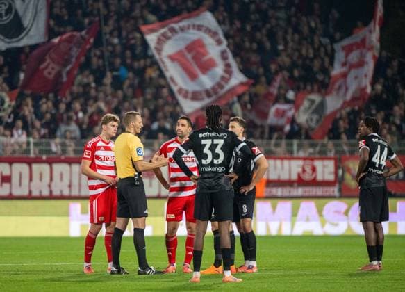 Fußball, Herren, Saison 2025 2026, 1. Bundesliga (9. Spieltag), 1. FC Union Berlin - SC Freiburg, langes Warten auf den Videobeweis nach dem vermeintlichen Tor von Andrej Ilic (1. FC Union Berlin) zum 1:0, v. l. Aljoscha Kemlein (1. FC Union Berlin), Schiedsrichter Sören Storks, Rani Khedira (1. FC Union Berlin), Jordy Makengo (SC Freiburg, Maximilian Eggestein (SC Freiburg, Johan Manzambi (Freiburg), 01.11.2025, Copyright: xMatthiasxKochx