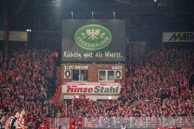 Deutschland: Fussball Bundesliga 2025 26, 9. Spieltag 1. FC Union Berlin vs SC Freiburg An der Alten Försterei (Berlin): Anzeigetafel im Stadion An der Alten Försterei mit dem Schriftzug Richtig gut die Wurst von Sponsor Eberswalder. Union-Fans in rot-weißen Farben füllen die Tribünen, Spielstand 0:0. Typische Heimspielstimmung in Berlin-Köpenick. Keywords: Union Berlin, Bundesliga, Stadion, Fans, Anzeigetafel, Eberswalder, Werbung, Fußball, Berlin. Berlin Deutschland Copyright: xJOERANxSTEINSIEKx
