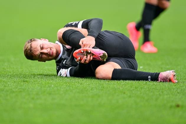 Marvin Obuz (Essen, 10) hält sich den linken Fuss, am Boden liegend, mit Schmerzen nach einem Foul, racked with pain, verletzt, Verletzung, injured, sporting injury, Freisteller, Einzelbild, Aktion, Action, 08.11.2025, Ingolstadt (Deutschland), Fussball, 3. Liga, FC Ingolstadt 04 - Rot-Weiss Essen, DFB DFL REGULATIONS PROHIBIT ANY USE OF PHOTOGRAPHS AS IMAGE SEQUENCES AND OR QUASI-VIDEO.