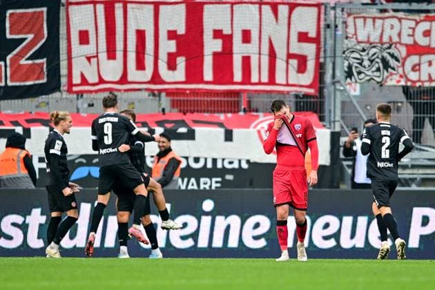 Essener Spieler mit Torjubel, Jubel, Torjubel, Torerfolg, celebrate the goal, goal, celebration, Jubel ueber das Tor zum 0:2, optimistisch, Action, Aktion, Jonas Scholz (FC Ingolstadt, 15) enttaeuscht schauend, Enttaeuschung, Frustration, disappointed, pessimistisch, 08.11.2025, Ingolstadt (Deutschland), Fussball, 3. Liga, FC Ingolstadt 04 - Rot-Weiss Essen, DFB DFL REGULATIONS PROHIBIT ANY USE OF PHOTOGRAPHS AS IMAGE SEQUENCES AND OR QUASI-VIDEO.