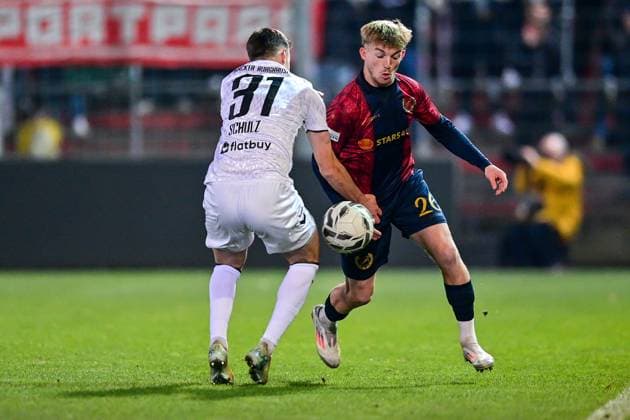 v.li.: Christoph Schulz (Burghausen, 31) Andy Breuer (Unterhaching, 26) im Zweikampf, Duell, duel, tackle, Dynamik, Action, Aktion, 18.11.2025, Unterhaching (Deutschland), Fussball, BFV Verbandspokal, Viertelfinale, SpVgg Unterhaching - SV Wacker Burghausen