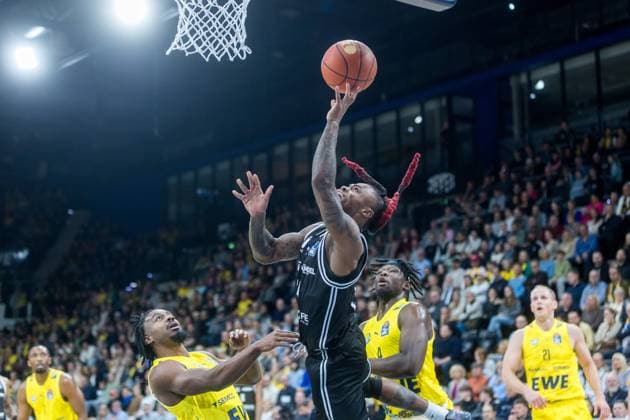Oldenburg, Niedersachsen, DEU, 22.11.2025, Cobe Williams (Mitte, BMA365 Bamberg Baskets), Christopher Clemons (links, EWE Baskets Oldenburg) und Brian Fobbs (rechts, EWE Baskets Oldenburg). EWE Baskets Oldenburg vs. BMA365 Bamberg Baskets. 1. Basketball-Bundesliga Saison 2025 2026, 8. Spieltag, Grosse EWE Arena. EWE Baskets Oldenburg vs. BMA365 Bamberg Baskets