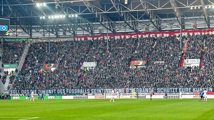 GER, 1. FBL, FC Augsburg vs Hamburger SV 22.11.2025, WWK-Arena, Augsburg, GER, 1. FBL, FC Augsburg vs Hamburger SV, im Bild koordinierte Fanproteste in den ersten 12 Spielminuten gegen Plaene (Sicherheitsmassnahmen) der Innenministerkonferenz (IMK), Soll das die Zukunft des Fussball sein?, Augsburger Fanblock